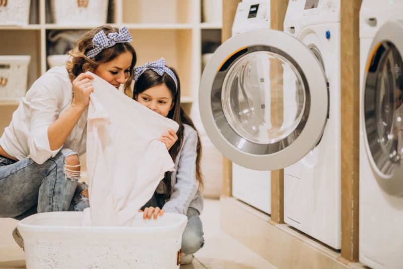 mother-with-daughter-doing-laundry-self-serviece-laundrette